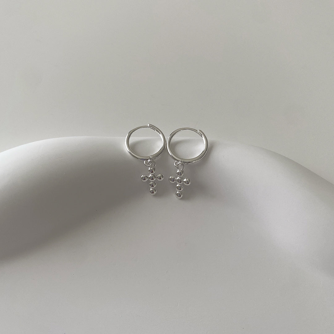 front view of silver dangling hoop earrings featuring mini bubble crosses. Made of 925 sterling silver