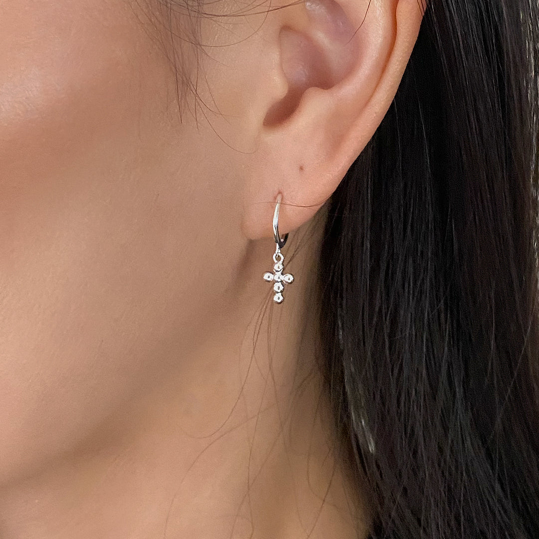 shop our mini bubble cross earrings made of 925 sterling silver on female model