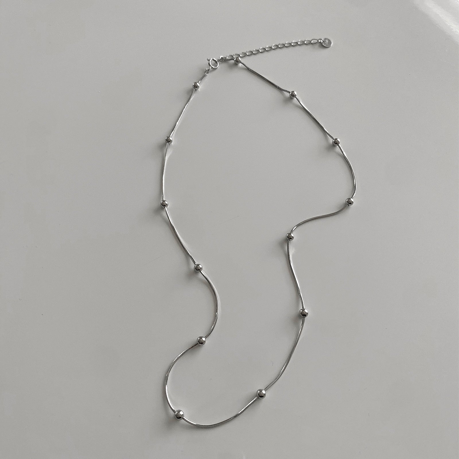 DAINTY BEADED NECKLACE FEATURES A SNAKE CHAIN WITH SILVER BEADS. THIS NECKLACE IS MADE OF 925 STERLING SILVER.