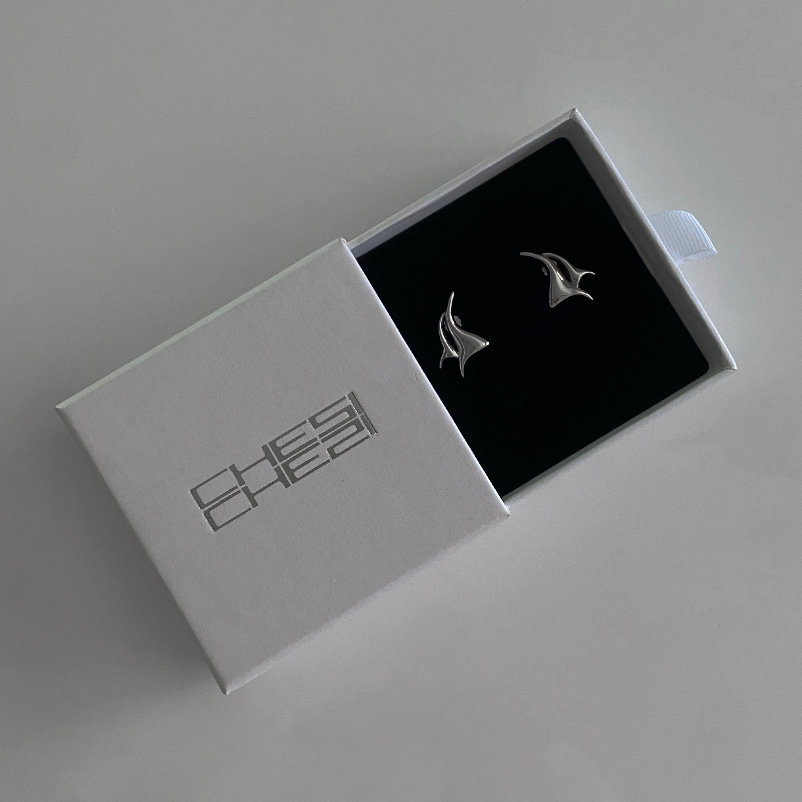 These flame studs feature a flame-like design and is made of 925 silver with rhodium plating for extra protection/strength. The image here shows the flame studs in our gift box packaging provided with each purchase.