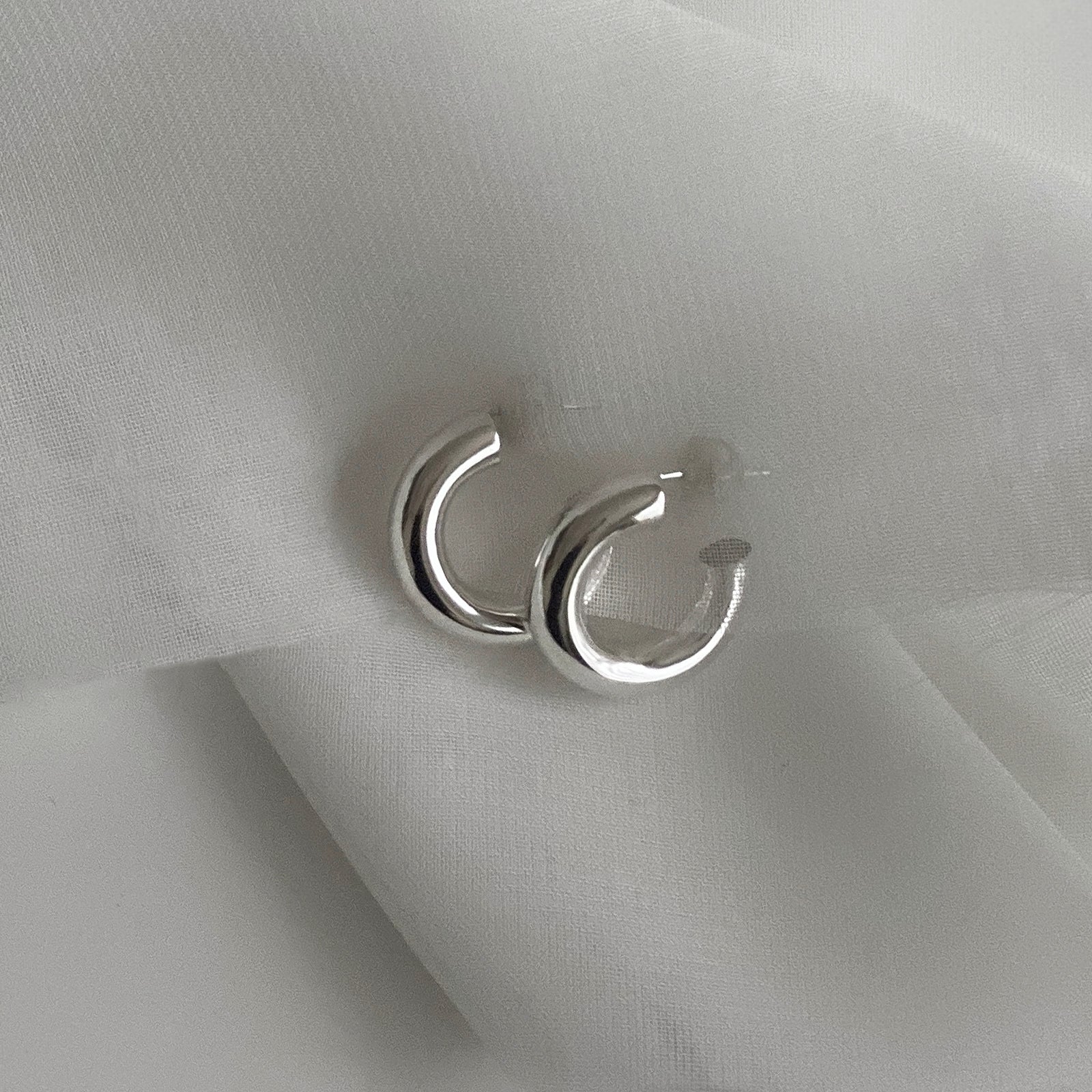 Detail view of the Hollow Tube Hoops. These hoop earrings are made of 925 sterling silver with a push back for closure. These earrings are lightweight and hollow.
